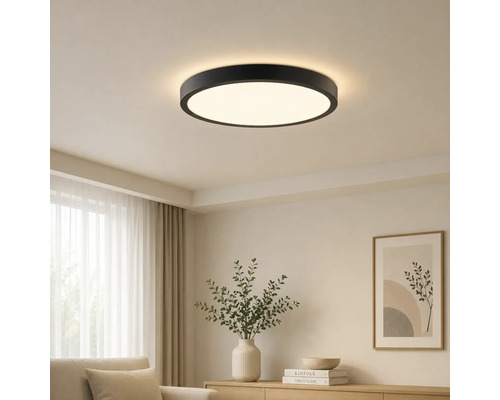 Moderní kulaté stropní LED svítidlo s černým rámem ve světlém obývacím pokoji.