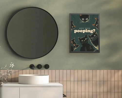 Moderní koupelna s kulatým zrcadlem, bílým umyvadlem, vertikálními dlaždicemi a obrazem s kočkami a textem are you pooping?