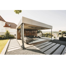 Moderní, světlá kovová pergola s dřevěnou lamelovou stěnou, závěsy a lounge nábytkem na dřevěné terase v zahradě.