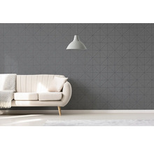 Moderní obývací pokoj s geometrickými strukturovanými stěnovými panely, pohovkou s přehozem a závěsným svítidlem.