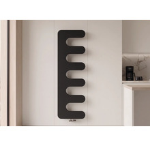 Černý designový radiátor ve tvaru hřebenu na bílé stěně ve světlé, moderní kuchyni.