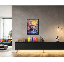 Světlý, moderní obývací pokoj s rámovaným pop-art obrazem Alberta Einsteina nad černou komodou s barevnými vázami.