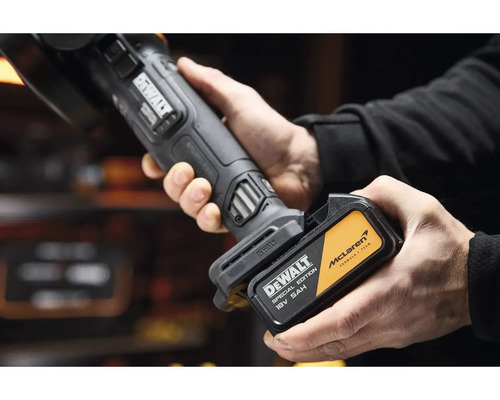 Ruce vkládají akumulátor DeWalt 18 Voltů 5 Ampérhodin McLaren Special Edition do akumulátorového nářadí.