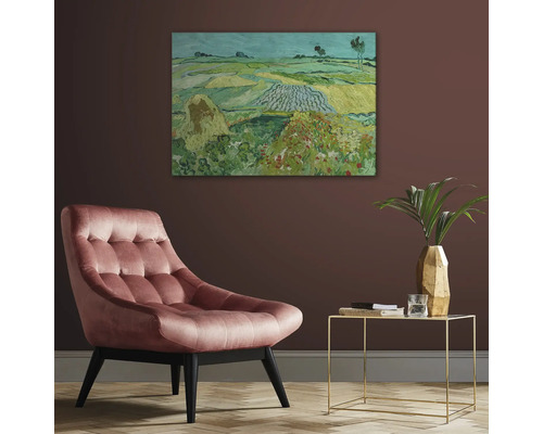 Umělecký tisk obrazu od Van Gogha v obývacím pokoji s čalouněným křeslem odkládacím stolkem a vázou s rostlinou.