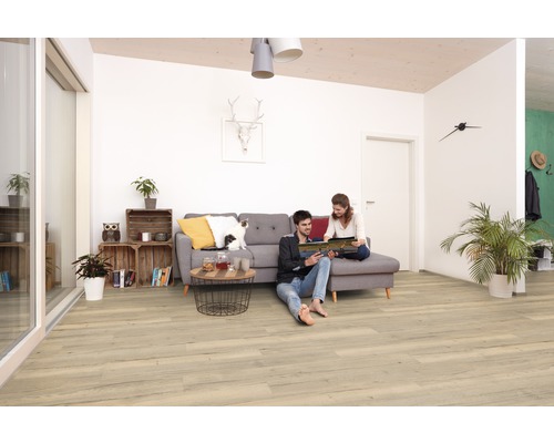 Obývací pokoj se světle hnědou dřevěnou podlahou, pohovkou a dvěma lidmi