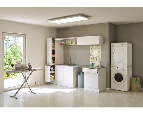 Světlá prádelna s pračkou, sušičkou, umyvadlem, skříněmi a žehlicím prknem