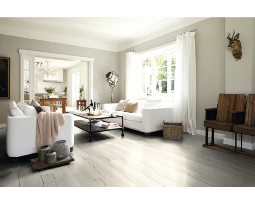 Světlý obývací pokoj s bílými pohovkami, dřevěnou podlahou a dekorativními prvky