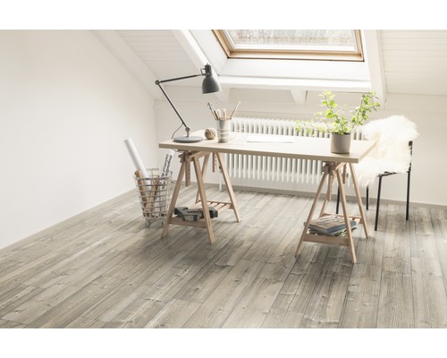Světlá místnost s dřevěnou podlahou, psacím stolem a střešním oknem