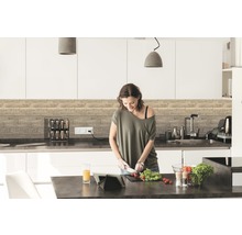 Moderní kuchyně s dřevěnými panely a žena krájející zeleninu