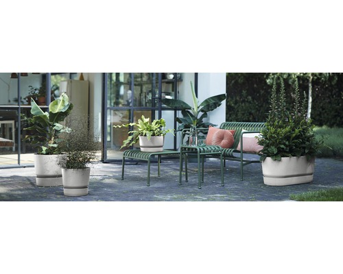 Venkovní scéna s různými rostlinami v květináčích a zahradním nábytkem