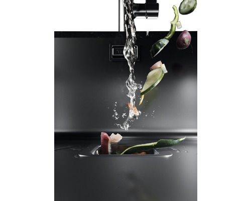 Kuchyňský dřez s tekoucí vodou a zeleninovým odpadem