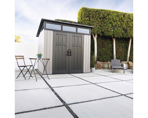 Zahradní scéna s kůlnou na nářadí, zahradním stolem a židlí na terase