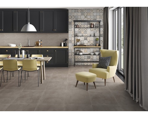 Ukázka místnosti s kuchyňským koutem, jídelním prostorem a křeslem na podlahových dlaždicích.