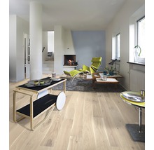 Světlý obývací pokoj s dřevěnou podlahou, krbem a moderním nábytkem.