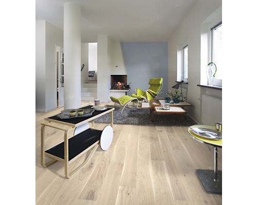 Světlý obývací pokoj s dřevěnou podlahou, krbem a moderním nábytkem.