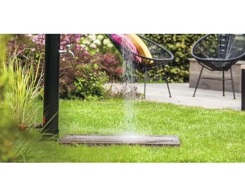 Zahradní scéna se stojací sprchou, trávníkem a venkovním posezením