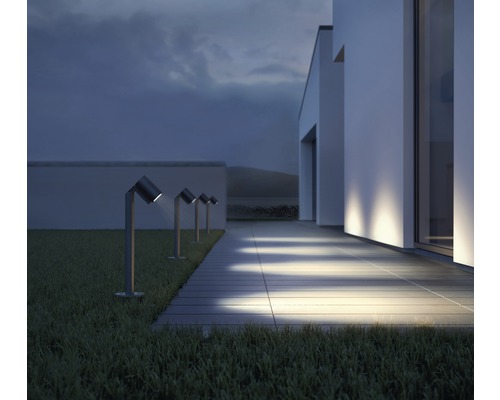 Řada zahradních svítidel podél chodníku před moderním domem