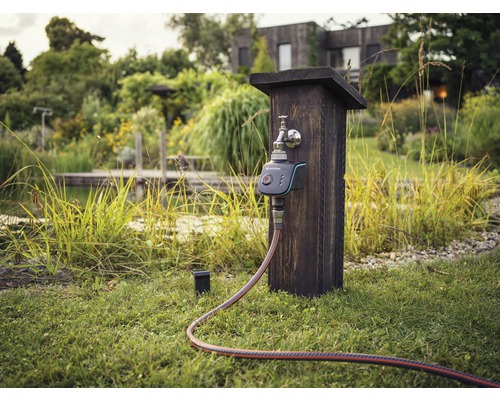 Řízení zavlažování s vodovodním kohoutkem a hadicí na zahradě