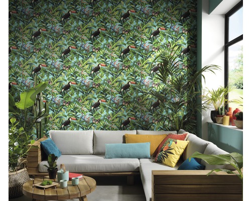 Obývací pokoj s tapetou se vzorem tropického tukana, šedou rohovou pohovkou a pokojovými rostlinami pro světlé a uspořádané prostředí.