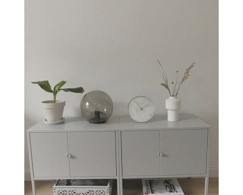 Příborník s pokojovou rostlinou, stolní lampou, hodinami a vázou