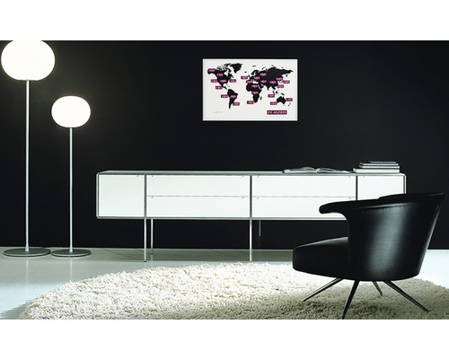 Interiér se dvěma stojacími lampami, příborníkem, křeslem a mapou světa na zdi.