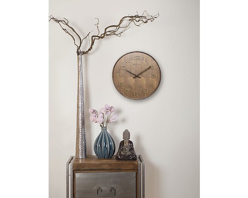 Dekorace obývacího pokoje s hodinami, vázami a soškou Buddhy na odkládacím stolku