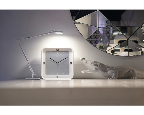 Dekorace se stolní lampou, hodinami a figurkou krokodýla před zrcadlem