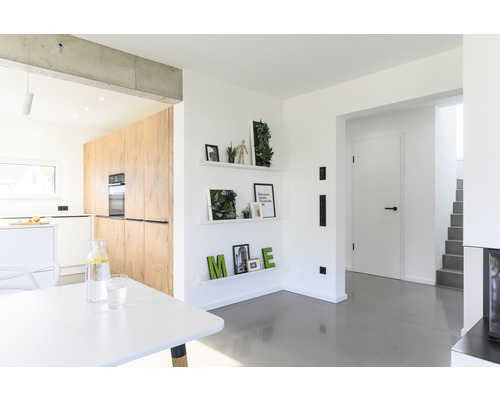 Světlý obývací pokoj s kuchyní, policemi a jídelním stolem