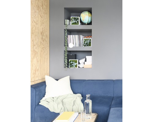 Obývací pokoj s modrou pohovkou, nástěnnou policí a dekorativními prvky pro design interiéru