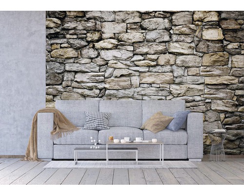 Obývací pokoj s kamennou tapetou a šedou pohovkou