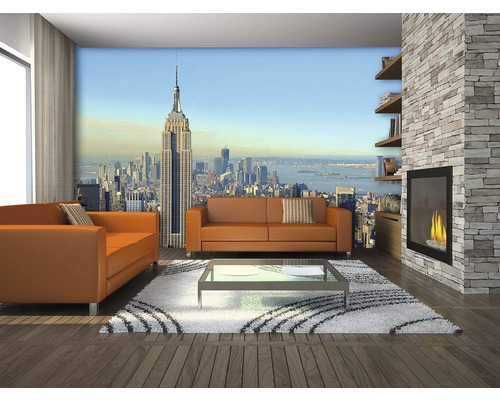 Obývací pokoj s fotografickou tapetou New York, pohovky, konferenční stolek, krb a knihovna