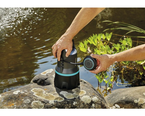 Zahradní scéna s rybníkem a ponorným čerpadlem v ruce