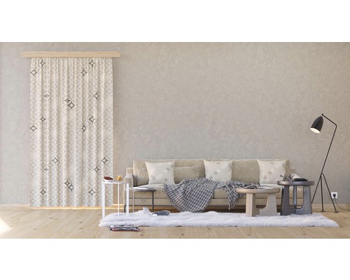 Obývací pokoj s pohovkou, závěsem se vzorem a stojací lampou