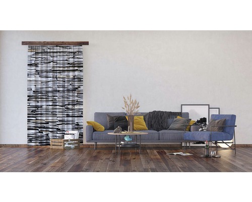 Obývací pokoj s posuvným závěsem se vzorem kamene, pohovkou, křeslem a dekoracemi.