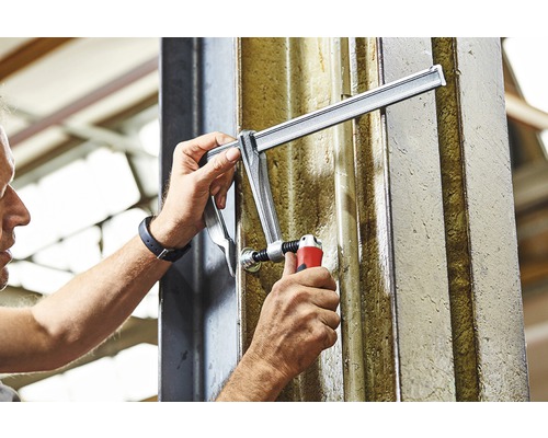 Osoba upevňuje svěrku na nosník.