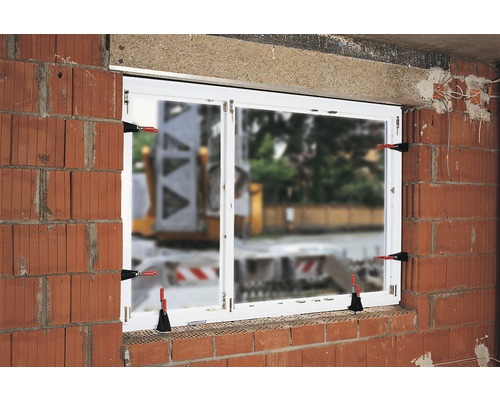 Vestavěné okno s upevňovacími sponami v cihlové zdi