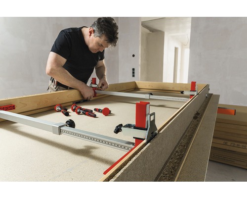 Muž pracuje s rozpěrákem zárubní dveří na rámu dveří