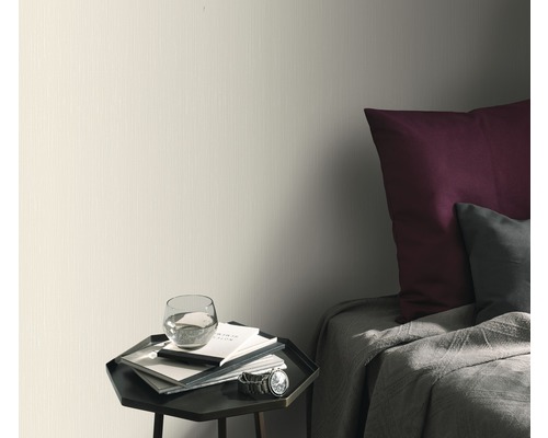 Světlá tapeta v ložnici s nočním stolkem a postelí