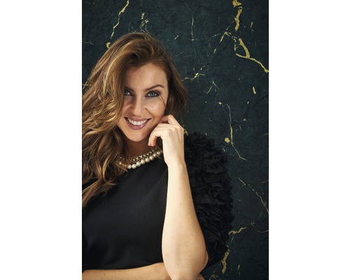 Portrét usmívající se ženy s perlovým náhrdelníkem a černými šaty