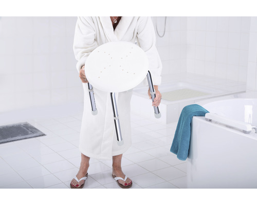 Žena v županu drží sprchovou stoličku