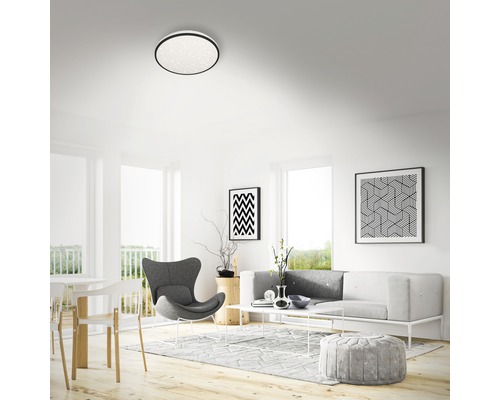 Světlý obývací pokoj se stropním svítidlem, pohovkou a dekorací