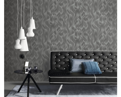 Obývací pokoj se šedou tapetou, černou pohovkou a bílými lampami