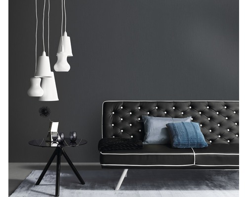 Obývací pokoj s černou pohovkou, odkládacím stolkem a závěsnými svítidly