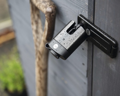 Visací zámek s logem Yale na dřevěných dveřích