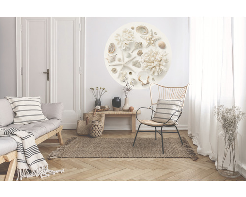 Obývací pokoj s pohovkou, židlí, kobercem a nástěnnou dekorací s mušlemi a hvězdicemi