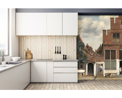 Moderní kuchyně s bílými skříňkami, dřevěnou pracovní deskou a nástěnnou malbou