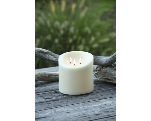 Dekorativní sloupová svíčka se třemi knoty na dřevěném stole