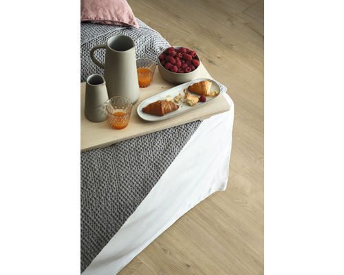 Snídaňový tác s džbánem, sklenicemi, malinami a croissanty na posteli