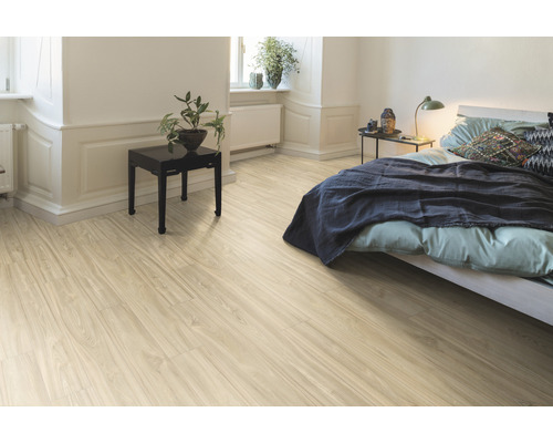 Ložnice se světle hnědou dřevěnou podlahou, postelí a nočním stolkem.