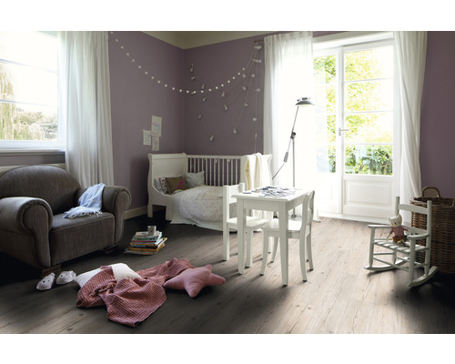 Dětský pokoj s postelí, křeslem, stolem a dřevěnou podlahou